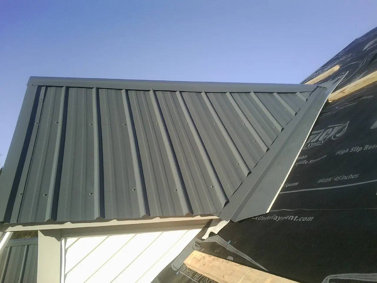 Gray metal roof panels going on over a garage gable in Westmoreland