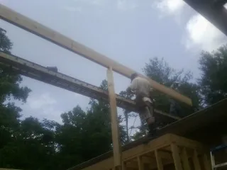 Carpenter setting a ridge beam over a new addition frame — Ice Dam Removal by Roofing Brothers in Westmoreland